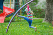 © nkarol - Active little girl climbing monkey bar outdoors on spring playground