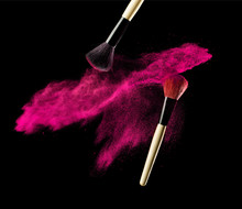Make-up Brush With Pink Powder Explosion On Black Background