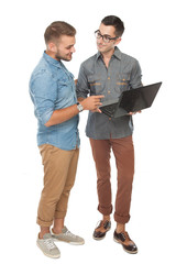 Two cheerful young man dicussing something on the laptop and smi