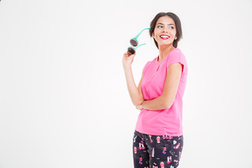 Poster - Smiling beautiful young woman standing and holding sunglasses