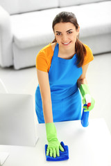 Wall Mural - Young woman cleaning workplace with computer monitor in the office