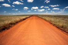 Rural Orange Dirt Road With Blue Sky And Far Horizon