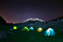 Illuminated Yellow Camping Tent Under Stars At Night