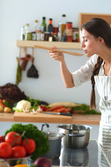 Wall Mural - Cooking woman in kitchen with wooden spoon