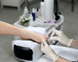 Cuticle removing in a beauty salon, on the background of the equipment