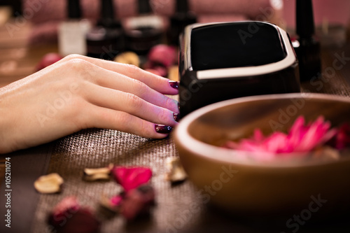 Photographie Closeup finger nail care by manicure specialist in beauty salon.