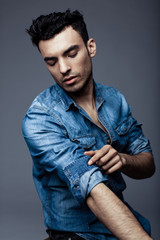 Wall Mural - Portrait of handsome young man in casual denim clothes standing over white background