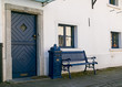 Altes Bauernhaus mit blauer Holztüre und blauem alten Briefkasten und Bank