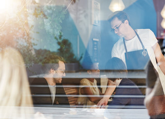 Wall Mural - Couple being served by a waiter in busy cafe