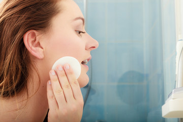 Wall Mural - Woman removing makeup with cotton swab pad.