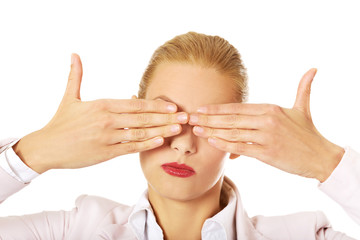 Wall Mural - Business woman covering her eyes with her hands. See no evil concept