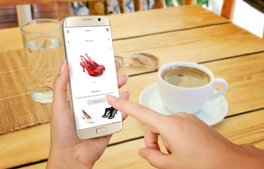 Wall Mural - Online shopping with smart phone. Isolated phone in woman hand. Buying women shoes on online store.