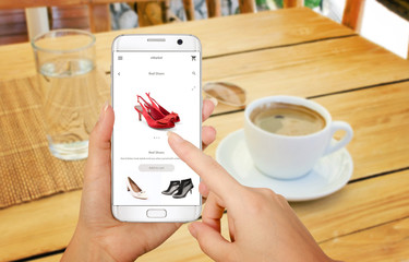 Wall Mural - Online shopping with smart phone. Isolated phone in woman hand. Buying women shoes on online store.