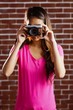 © WavebreakmediaMicro - Smiling asian woman taking picture with camera