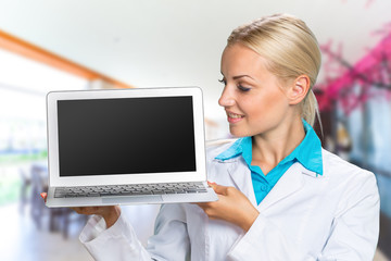 Wall Mural - Beautiful Caucasian woman doctor holding a laptop computer