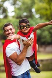 Fototapeta Uliczki - Father and son pretending to be superhero