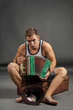 Portrait Of A Man With Accordion Sitting On Retro Suitcase