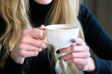 Woman holding cup of tea in a cafe