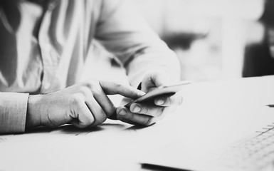 Wall Mural - Businessman working generic design laptop. Touching screen smartphone. Horizontal mockup, black white