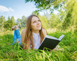 Beautiful girl in the meadow with a book 