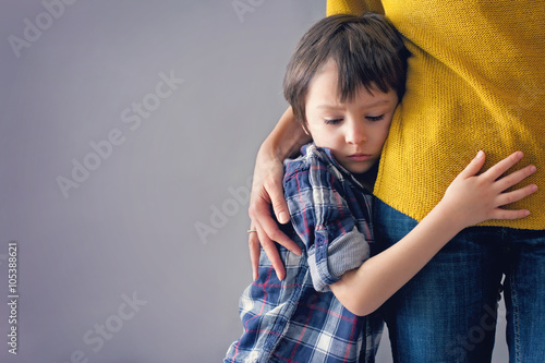 Fotografía Sad pequeño niño, muchacho, que abraza a su madre en el hogar