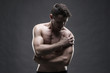 © staras - Pain in the shoulder. Muscular male body. Handsome bodybuilder posing on gray background. Low key close up studio shot