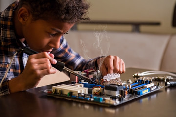 Afro boy fixing motherboard.