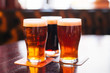 © Viiviien - Glasses of light and dark beer on a pub background.