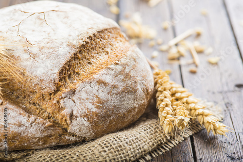 Fotomural Hogaza de pan de Cereales Variados Sobre arpillera Rústica con espigas de trigo