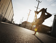 © Mint Images - A young man breakdancing on the street of a city, doing a one handed handstand,