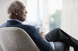 © Mint Images - Senior man sitting in chair, relaxing with cup of tea