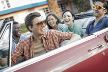 Group Of Friends In Red Convertible Car On  Road Trip