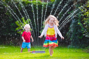 Kids playing with garden sprinkler