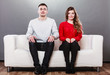 © Voyagerix - Shy woman and man sitting on sofa. First date.