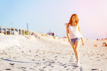 Canvas Print - Young woman walking along the beach