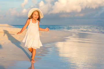 little girl walking on beautiful ocean beach