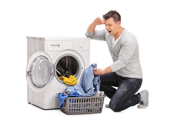 Poster - Displeased man emptying a washing machine