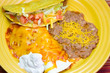 Mexican Combo Plate – A plate with cheese enchilada, refried beans, sour cream, and a meat taco.