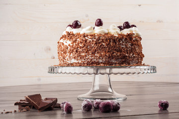 Black forest cake decorated with whipped cream and cherries. 