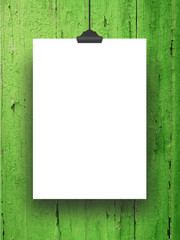 Close-up of one hanged blank frame with clip against green painted wood