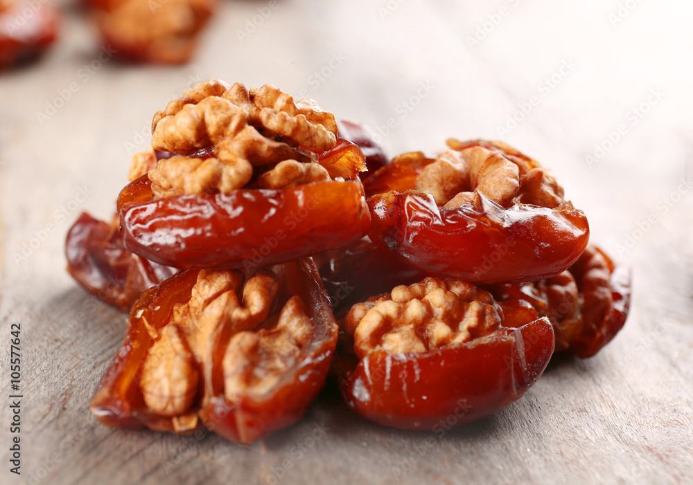 Walnut and date fruit on wooden table, close-up