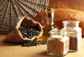 Wall Mural - Composition of seeds, bread and oil on beige background, closeup