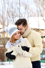 Wall Mural - Young couple embracing outdoors in winter