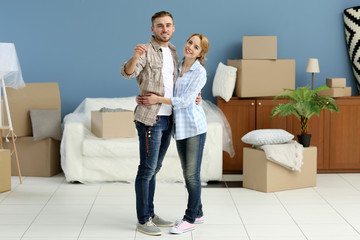 Wall Mural - Young happy couple holding keys from their new apartment