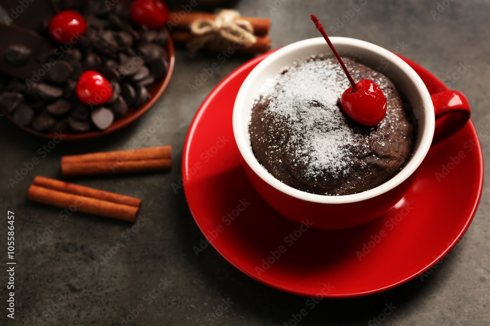 Chocolate cake in a red mug  with a cherry on top, close up