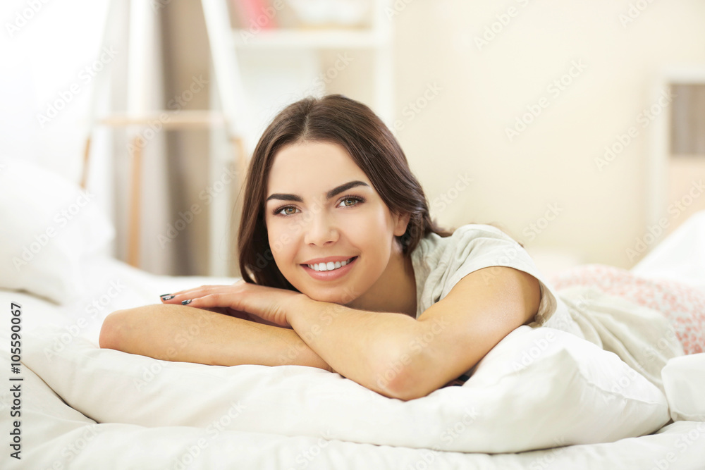 Beautiful young girl lying in the bedroom.