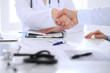 © rogerphoto - Doctor and patient handshaking. Hands close-up