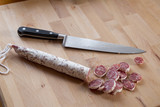 Fototapeta Tulipany - Close up of sliced iberian chorizo with knife