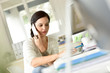 © goodluz - Woman in office talking on phone