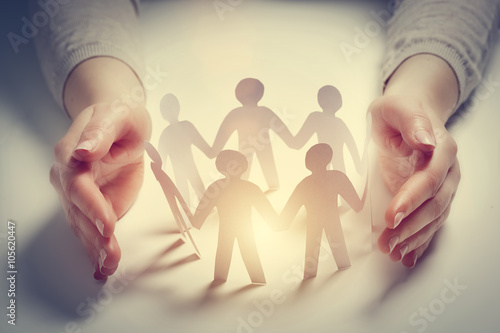 Fotografie, Obraz Paper people surrounded by hands in gesture of protection